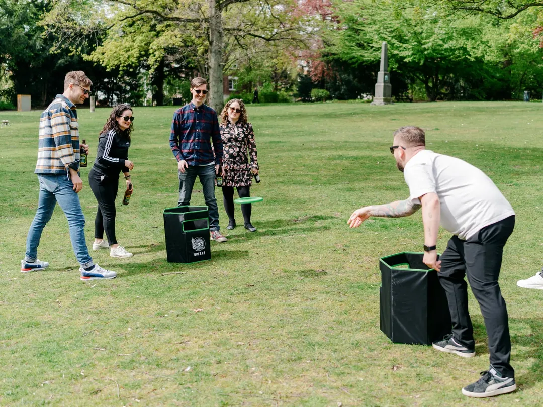 Eine Gruppe spielt ein Frisbee-Zielwurfspiel auf einer Grünfläche